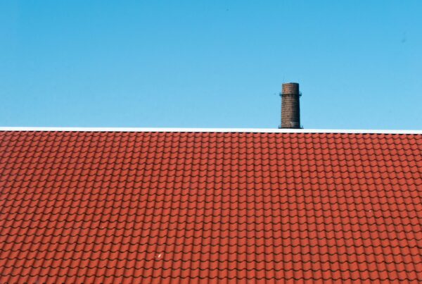 Blue sky and a red roof with terracotta shingles.